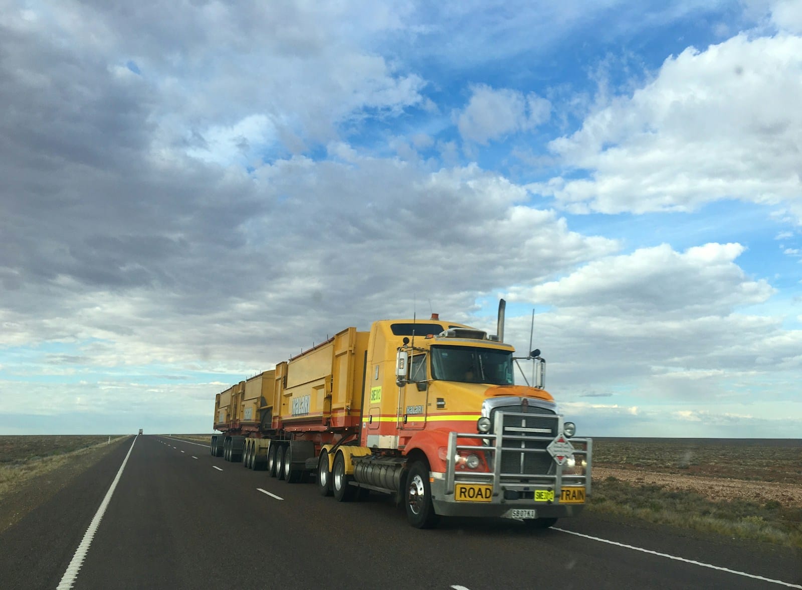 Road train travelling an outback Australian highway — the operating environment FRMS software protects