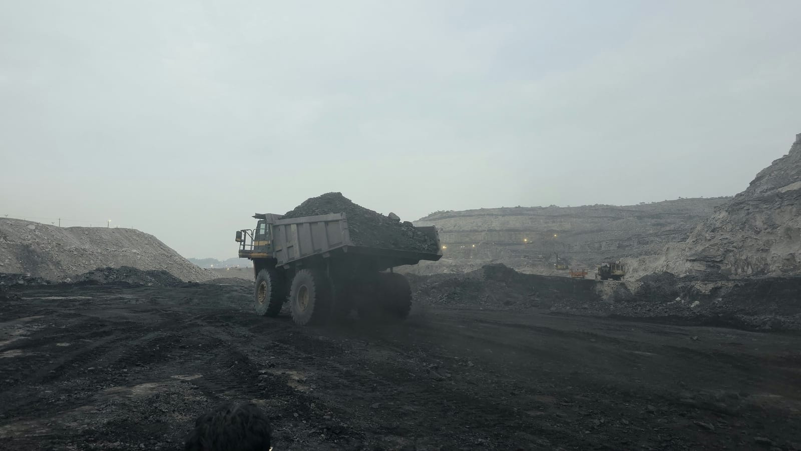 A loaded dump truck hauling out of an open-cut pit, the round-the-clock production that swing rosters exist to cover