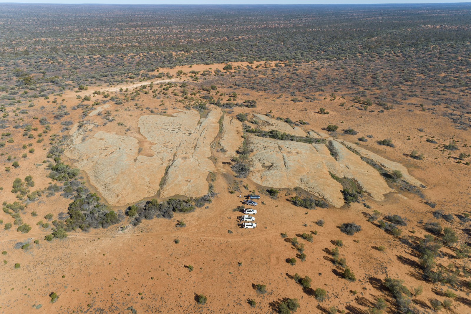Field crew vehicles on remote red-dirt country in outback Australia, the working environment mining workforce software has to serve