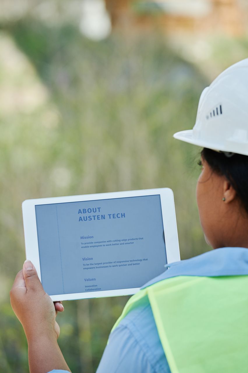 Field supervisor reviewing worker licences, tickets and induction records on a tablet at a construction site