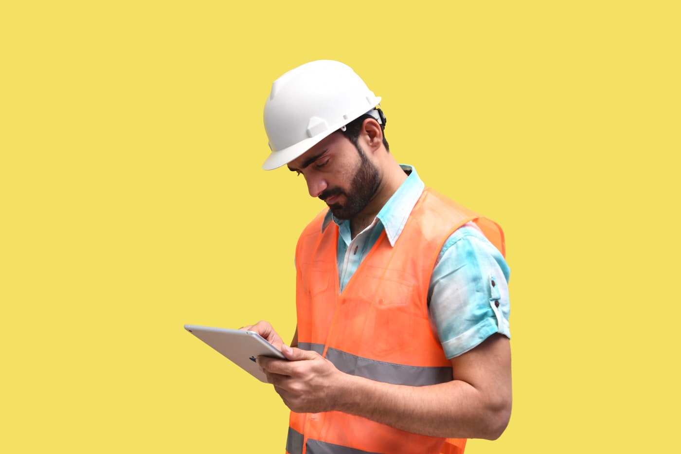 Site supervisor in hard hat and hi-vis reviewing submitted timesheets on a tablet