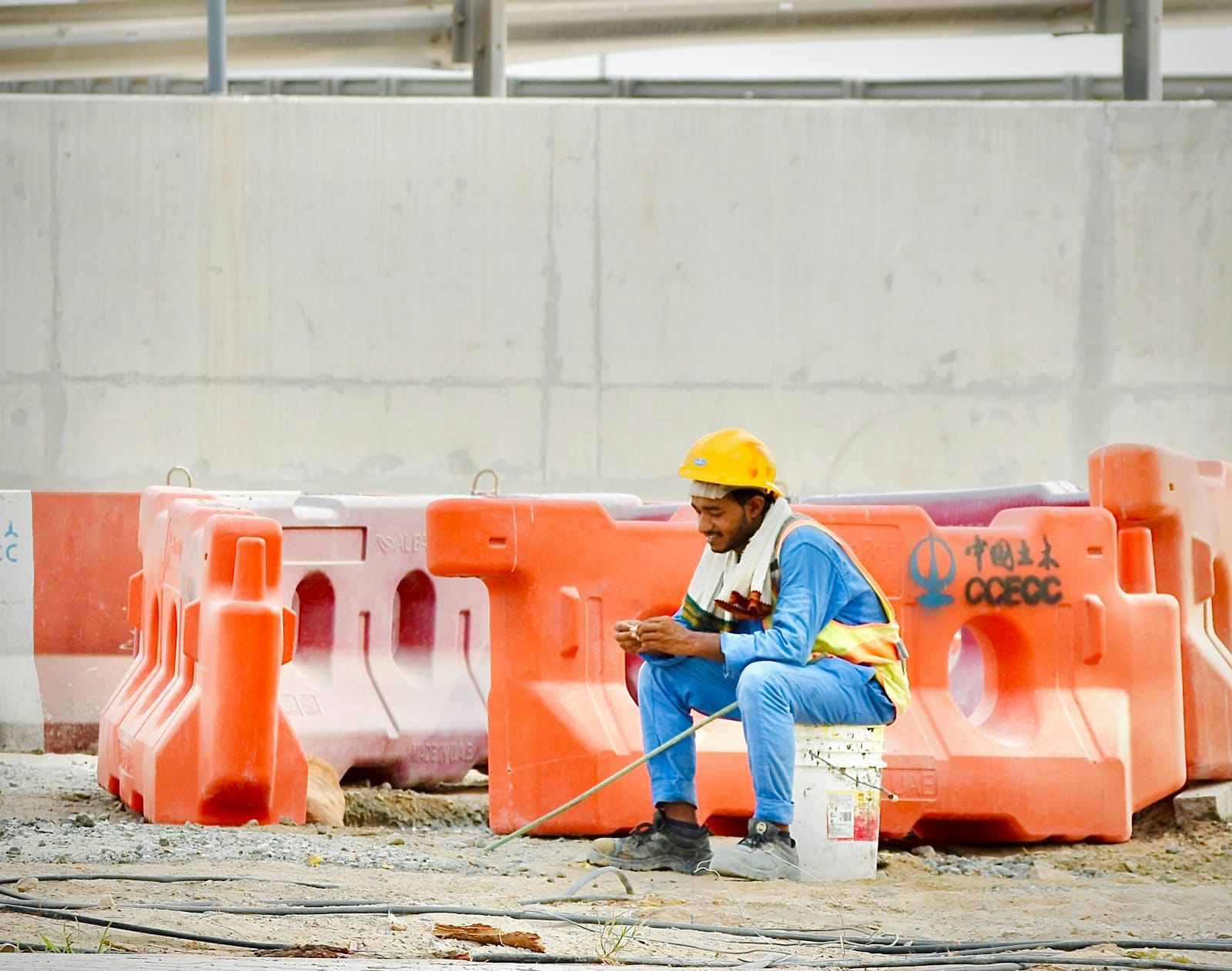 Construction worker in a hard hat recording time on his phone during a break on site