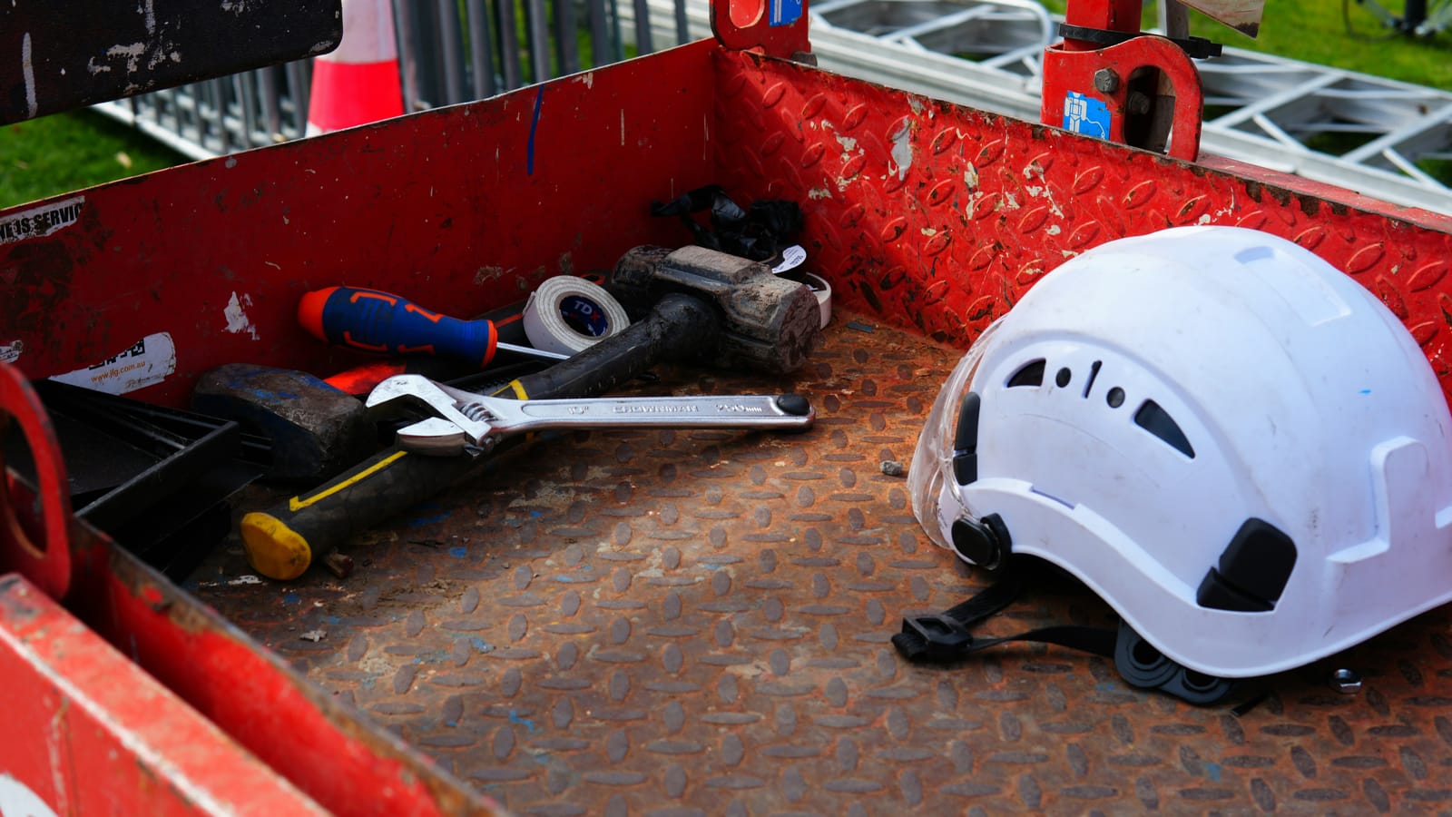 A hard hat and tools ready in a work basket, the gear side of a compliant crew