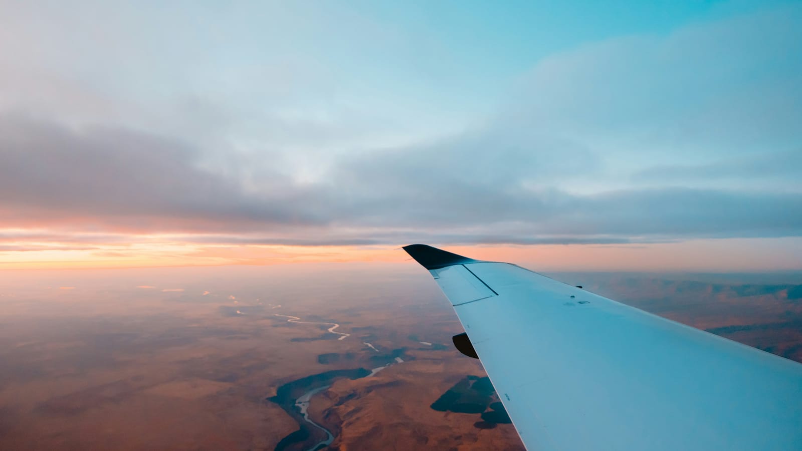 An aircraft wing over arid country at first light, the commute a swing roster is built around